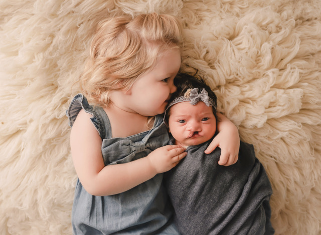 a child kissing a baby